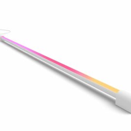 Das Bild zeigt die Philips Hue Play Gradient Light Tube in Weiß mit einer Länge von 125 cm. Sie liegt auf einer weißen Oberfläche und ist so positioniert, dass die gradienten Farbeffekte, von Pink zu Gelb übergehend, sichtbar sind. Die Light Tube ist dazu konzipiert, als Tischleuchte zu fungieren und bietet mit ihren Farbübergängen ein dynamisches Beleuchtungselement für die Raumgestaltung und Ambientebeleuchtung.