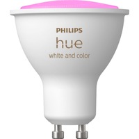 Das Bild zeigt eine "Philips Hue White & Color Ambiance GU10 LED-Lampe", die für intelligentes und farbenwechselndes Beleuchtungssystem konzipiert ist. Die Lampe hat einen GU10 Sockel und ist mit der typischen weißen Oberfläche sowie dem Philips Hue-Logo versehen. Die obere Hälfte der Lampe leuchtet in einem Farbton, was darauf hindeutet, dass die Lampe die Fähigkeit besitzt, in verschiedenen Farben zu leuchten. Das Bild dient dazu, das Produktdesign und die Farbwechselfunktion der Lampe zu veranschaulichen.