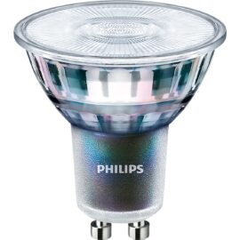 Das Bild zeigt die MASTER LEDspot ExpertColor 3.9-35W GU10 940 36D LED-Lampe von Philips. Man sieht eine Nahaufnahme der LED-Lampe mit klarem, facettierten Glühbirnenkopf und einem silbernen, strukturierten Körper, auf dem prominent das Philips-Logo platziert ist. Am unteren Ende befinden sich zwei Metallstifte für den GU10-Sockel. Das Bild dient dazu, das Design und die physische Beschaffenheit der LED-Lampe zu zeigen, einschließlich des speziellen GU10 Anschlusses, der für die Kompatibilität mit gleichartigen Fassungen konzipiert wurde.