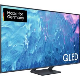 Das Bild zeigt einen QLED-Fernseher vom Modell GQ-55Q70C, der auf einem Standfuß steht. Auf dem Bildschirm ist eine lebendige und farbenfrohe abstrakte Visualisierung zu sehen, die die Bildqualität des Fernsehers hervorhebt. In der oberen Ecke des Bildes befindet sich ein Logo mit der Aufschrift "Made for Germany", was bedeutet, dass das Produkt speziell für den deutschen Markt gefertigt wurde. Auf der rechten Seite unten am Bildschirm ist das Wort "QLED" zu erkennen, was auf die Display-Technologie des Fernsehers hinweist. Der Zweck des Bildes ist es, die hohe Bildqualität und das Design des GQ-55Q70C QLED-Fernsehers zu präsentieren.