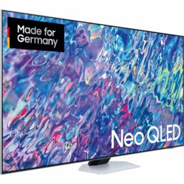 Das Bild zeigt den "GQ-75QN85B QLED-Fernseher" von Samsung. Zu sehen ist die Vorderansicht des Fernsehers, der ein farbintensives, abstraktes Bild anzeigt, um die Qualität des QLED-Displays zu demonstrieren. Im oberen linken Bereich des Bildschirms befindet sich ein Label mit dem Schriftzug "Made for Germany" und darunter das Logo "Neo QLED", welches auf die Bildschirmtechnologie hinweist. Der Fernseher ist auf einem einfachen, flachen Standfuß montiert. Der Zweck des Bildes ist es, den Fernseher in seiner ganzen Pracht zu präsentieren und die hochwertige Bildwiedergabe zu betonen.