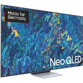 Das Bild zeigt den Samsung Neo QLED GQ-85QN95B QLED-Fernseher. Der Bildschirm ist mit einem lebendigen, farbenfrohen Muster dargestellt, das die hohe Bildqualität und Farbintensität des Neo QLED Displays hervorhebt. Auf dem Bildschirm ist auch ein "Made for Germany" Label sichtbar. Der Fernseher selbst hat ein schlankes Design mit schmalen Rändern, was auf eine moderne und unaufdringliche Erscheinung hinweist. Der Standfuß ist ebenfalls zu sehen und wirkt elegant und stabil. Das Bild dient der Präsentation des Produktdesigns und der Displayqualität des Samsung Neo QLED-Fernsehers.