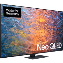 Das Bild zeigt den Samsung Neo QLED GQ-85QN95C QLED-Fernseher. Auf dem Bildschirm ist eine lebendige und farbenfrohe grafische Darstellung zu sehen, die die Farbqualität und die Bildschärfe des Fernsehers hervorheben soll. Ein "Made for Germany"-Logo befindet sich in der oberen linken Ecke, wobei das Wort "Neo QLED" prominent in der unteren Bildhälfte platziert ist, um das Modell zu kennzeichnen. Der Fernseher selbst hat einen schmalen Rahmen und steht auf einem rechteckigen Standfuß, was ein modernes und elegantes Design suggeriert. Das Bild dient dazu, die visuellen Merkmale und das Design des Produkts attraktiv zu präsentieren.